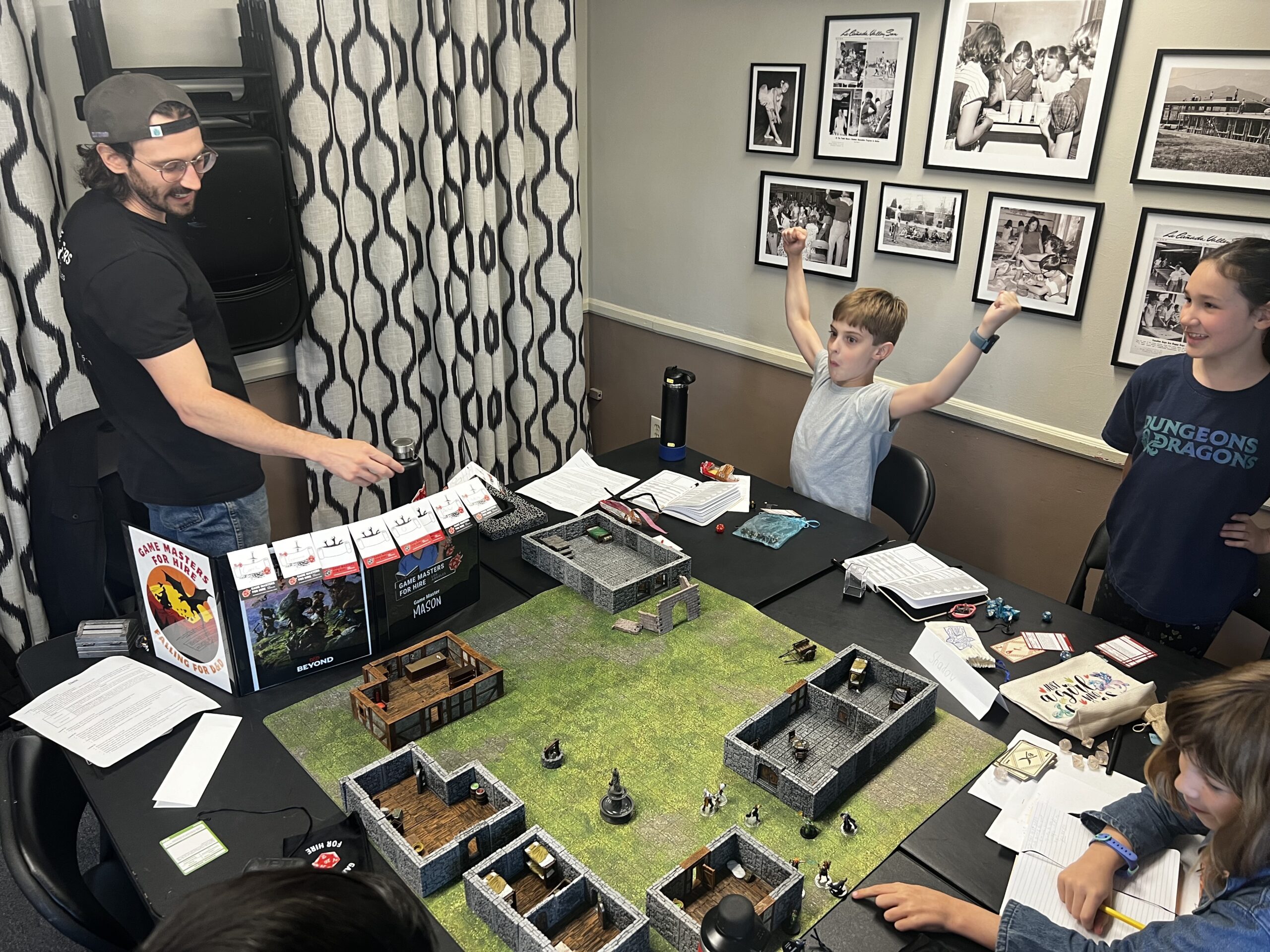 A boy playing Dungeons & Dragons raises his arms in victory.