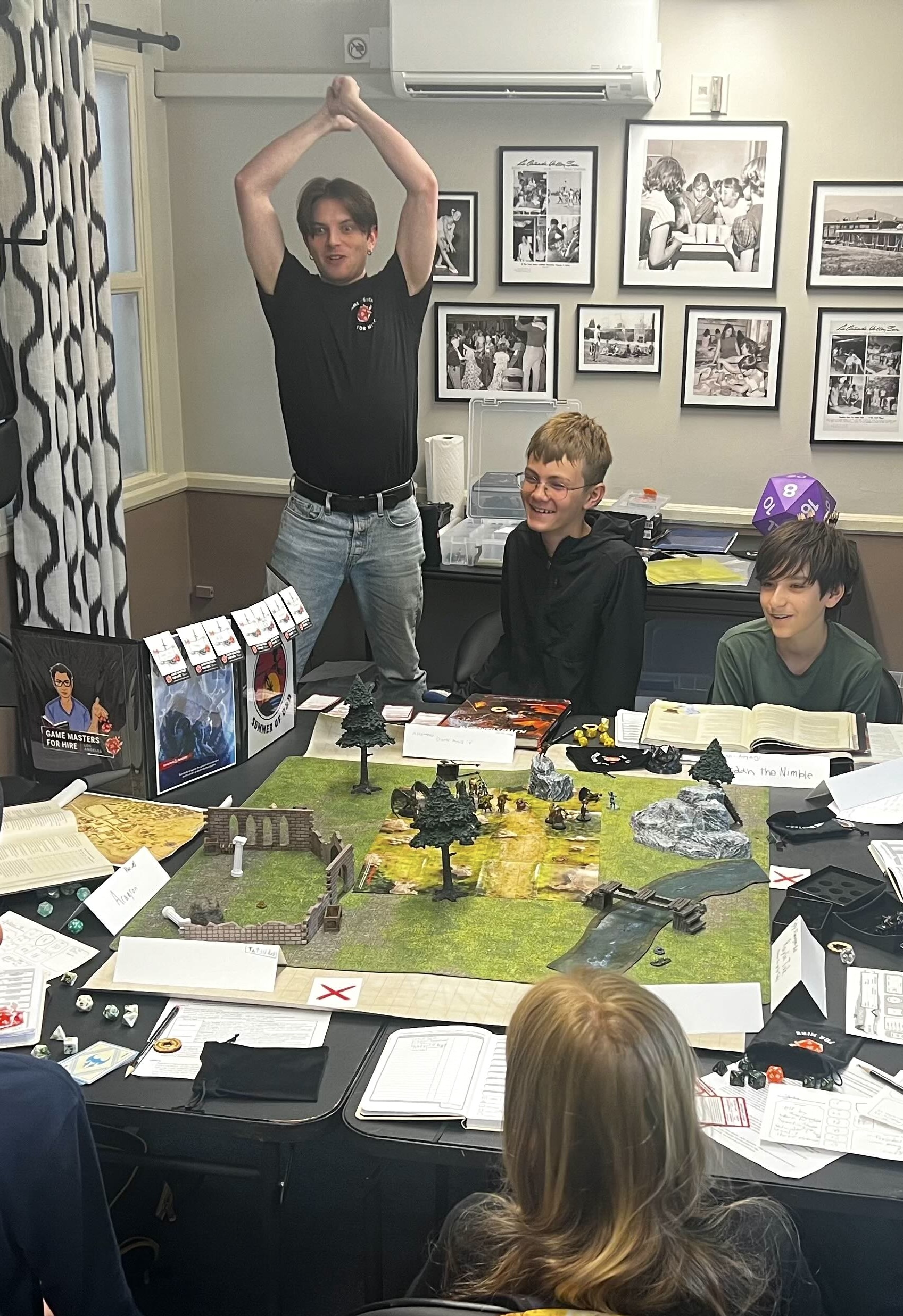 A Dungeon Master pretends to swing a sword for a group of players during a game of Dungeons & Dragons.