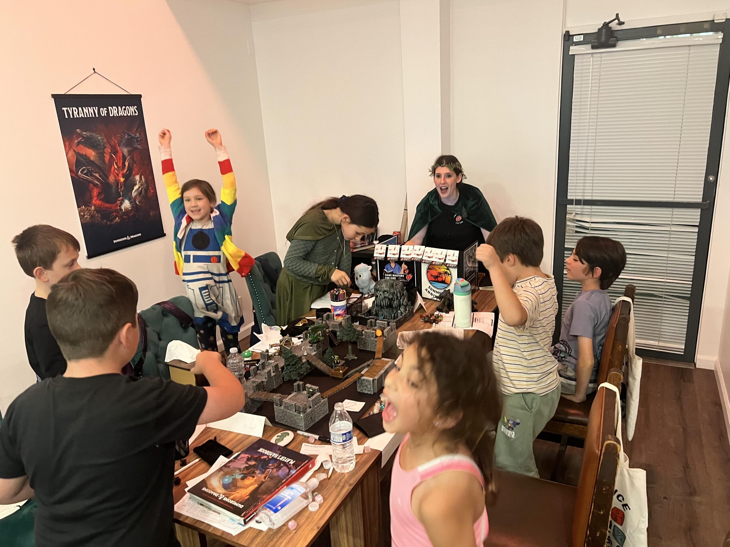 A group of kids point to a the game figures in front of them while playing Dungeons & Dragons.